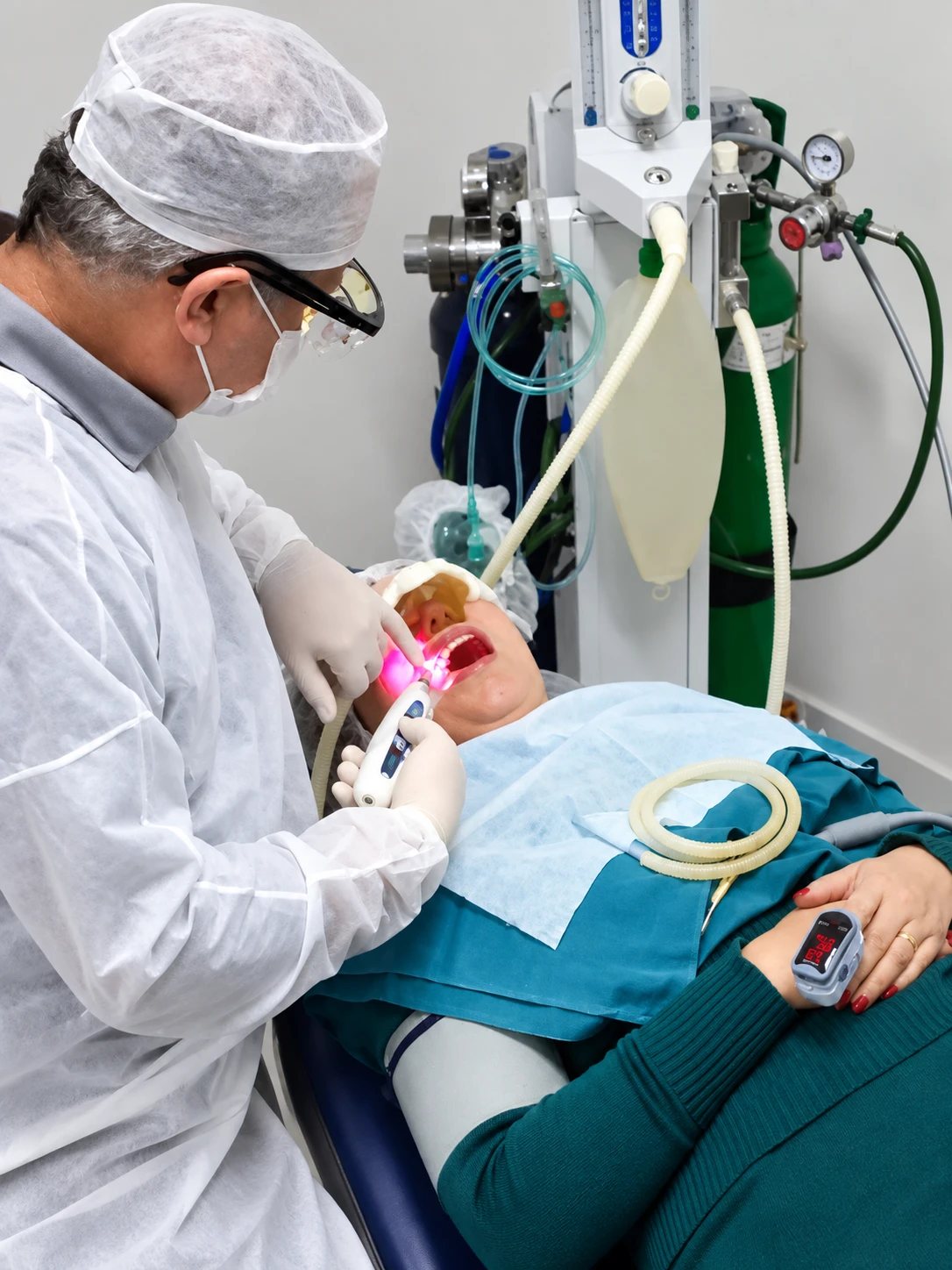 Dr. Marco Jardim atendendo paciente sob Sedação Consciente, com equipamento de oxigênio e óxido nitroso e oxímetro